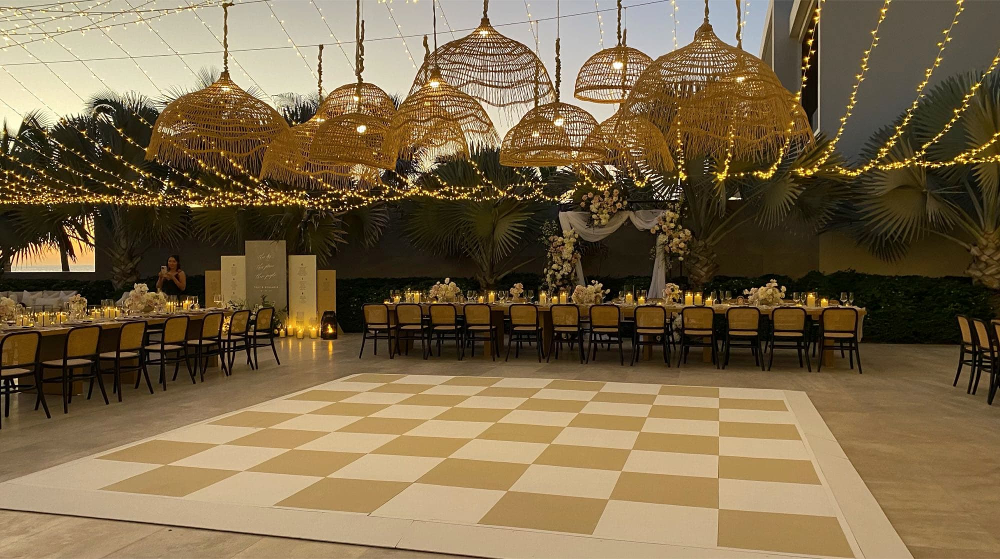 Checkerboard dance floor under woven lamps